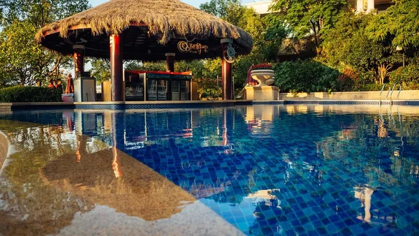 Recepção de hotel moderno com balcão iluminado e poltronas ao fundo