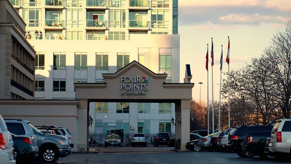 Recepção de hotel moderno com balcão iluminado e poltronas