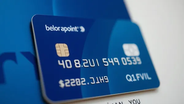 Cartões de crédito empilhados sobre calculadora e documento com tabela de limites de transferência de pontos
